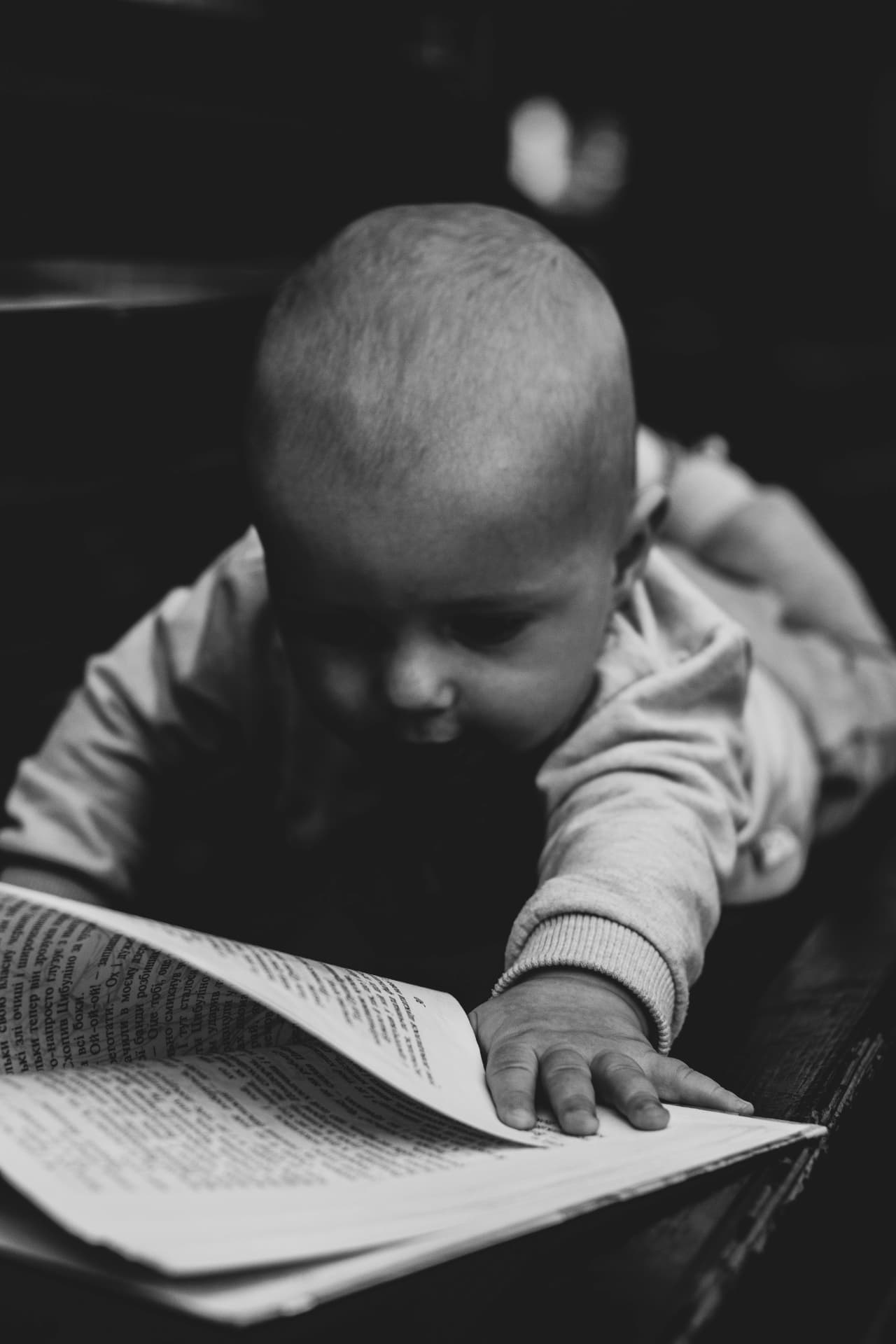 A baby reaching toward the pages of a book