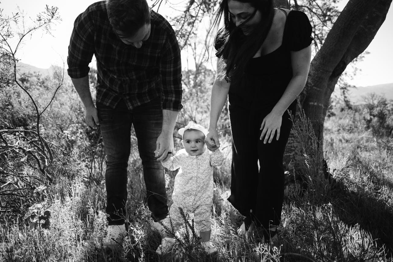 Parents helping their baby take first steps
