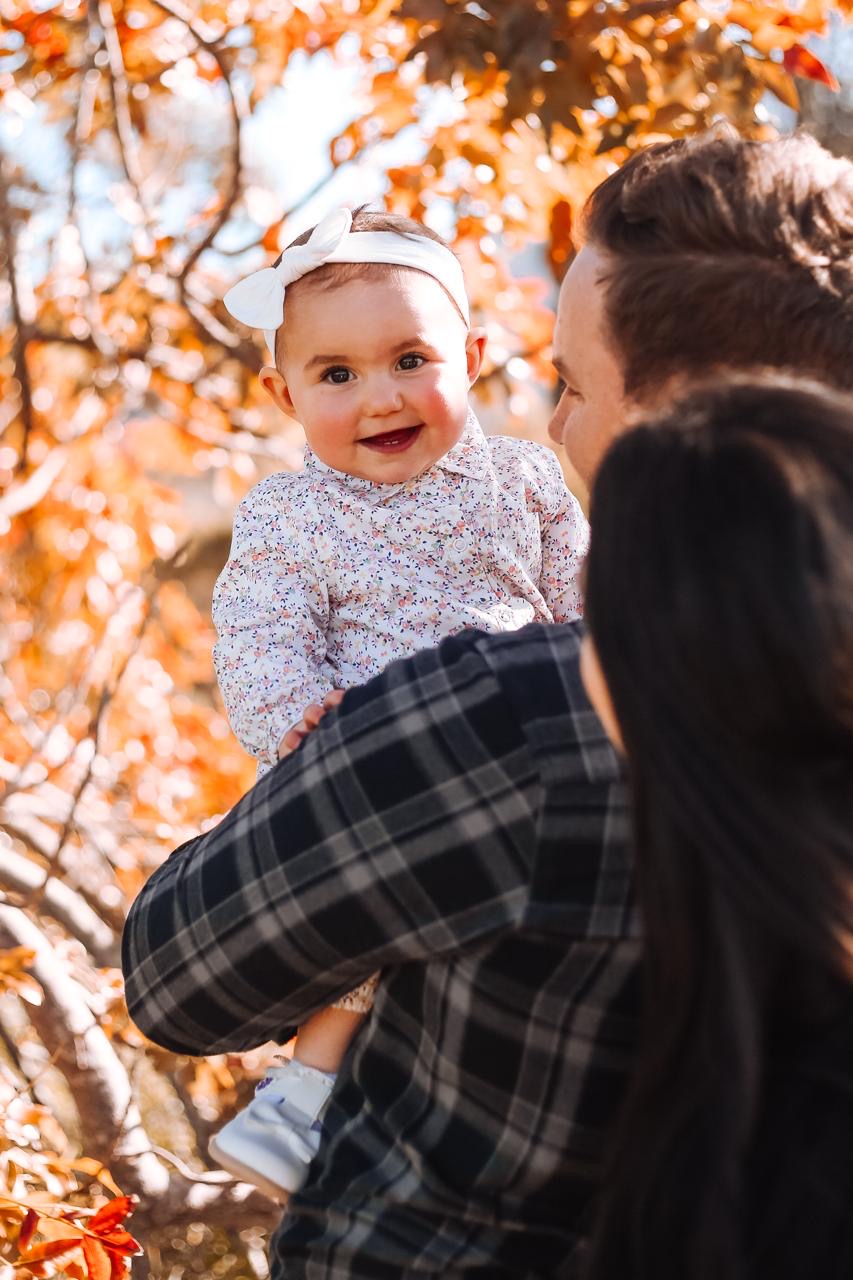Parents sharing a joyful autumn moment with their baby